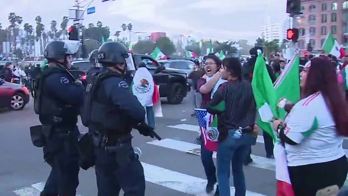 Police in riot gear moving towards protesters